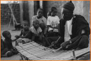 Grandfather Wamian Kone plays the bala xylophone for his grandchildren and friends.